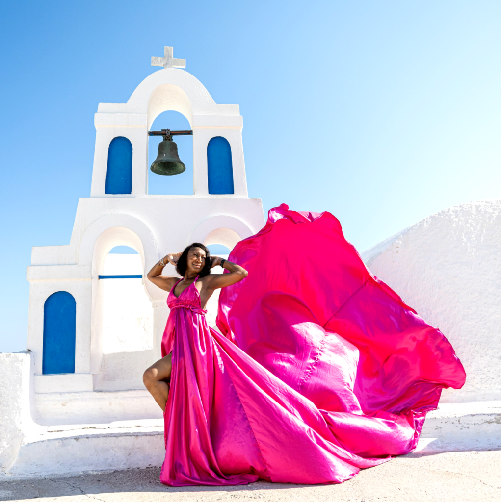 Latica posing in a pink dress in front of a bell statue